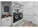 Well-organized laundry room with modern washer and dryer, built-in shelving, and a utility sink at 4769 Swordfish Dr, Raleigh, NC 27603