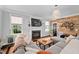 Stylish living room with a fireplace, wood accent wall, comfortable sectional sofa, and ample natural light at 4769 Swordfish Dr, Raleigh, NC 27603