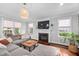 Bright living room with a fireplace, large windows, a comfortable sectional sofa, and a stylish coffee table at 4769 Swordfish Dr, Raleigh, NC 27603