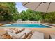 Relaxing poolside view with comfortable loungers and a clear blue pool surrounded by lush greenery and privacy wall at 4769 Swordfish Dr, Raleigh, NC 27603