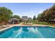 Beautiful backyard pool with sun loungers, an umbrella, and a charming pool house, perfect for summer relaxation at 4769 Swordfish Dr, Raleigh, NC 27603