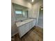 Bathroom vanity with granite countertops and double sinks, wood-look floors, with large mirror at 49 Heatherglenn Cir, Princeton, NC 27569