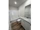 Well-lit bathroom featuring a shower-tub combo with a granite vanity and wood-look floors at 49 Heatherglenn Cir, Princeton, NC 27569