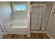 Bright bathroom showcasing a tub, window, and a glass-enclosed shower at 49 Heatherglenn Cir, Princeton, NC 27569