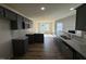 Modern kitchen featuring dark cabinets, granite countertops, stainless steel appliances, and wood flooring at 49 Heatherglenn Cir, Princeton, NC 27569