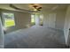 Spacious main bedroom features carpeted flooring, a ceiling fan, tray ceilings, and ample natural light at 49 Heatherglenn Cir, Princeton, NC 27569