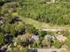 Stunning aerial view showcasing a property alongside a verdant golf course, surrounded by mature trees at 4912 Sunset Forest Cir, Holly Springs, NC 27540
