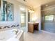 Spa-like bathroom with soaking tub, separate shower, and vanity area at 4912 Sunset Forest Cir, Holly Springs, NC 27540