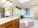 Luxurious bathroom featuring a soaking tub, skylight, dual sinks, and a separate shower at 4912 Sunset Forest Cir, Holly Springs, NC 27540