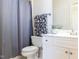 Cozy bathroom with white vanity, patterned hand towel, and a shower with a gray curtain at 4912 Sunset Forest Cir, Holly Springs, NC 27540
