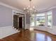 Formal dining room boasts hardwood floors, large windows, modern lighting, and wainscoting at 4912 Sunset Forest Cir, Holly Springs, NC 27540
