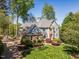 Beautiful two-story home featuring a well-manicured lawn, stone accents, and mature trees at 4912 Sunset Forest Cir, Holly Springs, NC 27540