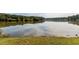 Scenic lake view with serene waters reflecting the sky and lush greenery along the shoreline at 4912 Sunset Forest Cir, Holly Springs, NC 27540