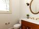 Charming powder room featuring a wood vanity, oval mirror, and elegant lighting fixture at 4912 Sunset Forest Cir, Holly Springs, NC 27540