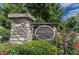 Stone community sign for Creek View at Traditions with lush greenery and colorful roses surrounding it at 518 Oak Forest View Ln, Wake Forest, NC 27587