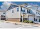 Two-story townhome with cream siding, brick accents, attached garage, and a manicured lawn with small shrubs at 518 Oak Forest View Ln, Wake Forest, NC 27587