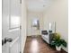 Bright entryway hallway with hardwood floors, a bench, and a decorative plant at 518 Oak Forest View Ln, Wake Forest, NC 27587