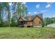 Back exterior of a home with a screened-in porch, a grassy yard, and large trees on the perimeter at 518 Ranch Farm Rd, Raleigh, NC 27603
