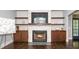 Living room featuring a stone fireplace with wooden shelves, hardwood floors, and modern decor at 518 Ranch Farm Rd, Raleigh, NC 27603