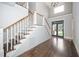 Welcoming foyer with dark hardwood floors and staircase with white railing, and tall windows at 518 Ranch Farm Rd, Raleigh, NC 27603