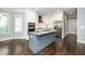 Bright eat-in kitchen with a gray island, granite countertops, stainless appliances, and tile backsplash at 518 Ranch Farm Rd, Raleigh, NC 27603