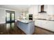 Eat-in kitchen featuring a gray island, white cabinets, stainless appliances, and hardwood flooring at 518 Ranch Farm Rd, Raleigh, NC 27603
