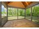 Screened in porch with wood flooring overlooking the surrounding backyard and trees at 518 Ranch Farm Rd, Raleigh, NC 27603