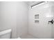 Bathroom with tiled shower, window, and built-in shelving niche at 518 Ranch Farm Rd, Raleigh, NC 27603