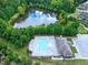 Aerial view of the community pool, clubhouse, and lake surrounded by nature at 521 Rockcastle Dr, Cary, NC 27519