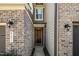 Welcoming front entrance with brick and siding, featuring a classic wooden door and stylish outdoor lighting at 521 Rockcastle Dr, Cary, NC 27519