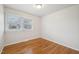 A well-lit bedroom has a large window offering natural light and hardwood floors for a comfortable retreat at 5218 Revere Rd, Durham, NC 27713
