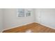 This bedroom features gleaming hardwood floors and a light-filled window with tree views at 5218 Revere Rd, Durham, NC 27713