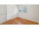 A cozy bedroom includes a window with blinds and a built-in closet, with natural light and hardwood floors at 5218 Revere Rd, Durham, NC 27713