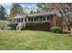 Well-maintained brick home with mature landscaping, offering classic charm and curb appeal at 5218 Revere Rd, Durham, NC 27713
