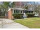 View of a charming brick home featuring a manicured lawn and a convenient driveway at 5218 Revere Rd, Durham, NC 27713