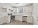 This kitchen features stainless steel appliances, white cabinets, and a window providing natural light at 5218 Revere Rd, Durham, NC 27713
