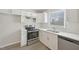 A clean kitchen offers stainless steel appliances, ample white cabinetry and countertop space, with a view from the window at 5218 Revere Rd, Durham, NC 27713