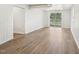 Open concept living area with wood-look flooring and sliding glass door to yard at 5218 Revere Rd, Durham, NC 27713
