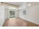 Large, sunny living room features wood-look flooring and access to the backyard at 5218 Revere Rd, Durham, NC 27713