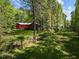 Backyard of a red house, partially obscured by the surrounding forest trees at 5401 Friends School Rd, Durham, NC 27705