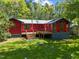 Expansive backyard featuring a lush lawn, wooden deck, and a charming red house at 5401 Friends School Rd, Durham, NC 27705