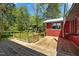 Large wooden deck outside with red shed/building and wooded backyard at 5401 Friends School Rd, Durham, NC 27705