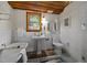 Bathroom features a clawfoot tub, pedestal sink, and white tiled walls and patterned floor at 5401 Friends School Rd, Durham, NC 27705