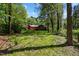 Charming red home nestled amongst mature trees and lush greenery on a spacious, well-manicured lot at 5401 Friends School Rd, Durham, NC 27705