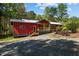 Exterior view of a red home with a welcoming front porch, showcasing the well-maintained landscaping and curb appeal at 5401 Friends School Rd, Durham, NC 27705