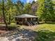 Charming wooden house with a metal roof, elevated on stilts, and dual staircases at 5401 Friends School Rd, Durham, NC 27705