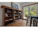 Cozy reading nook featuring a rustic wooden bookcase, wooden floors, and double doors leading to the outside at 5401 Friends School Rd, Durham, NC 27705