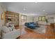 Open-concept living room with hardwood floors, a large blue sofa, and plenty of natural light from large windows at 5401 Friends School Rd, Durham, NC 27705
