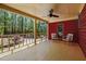 Inviting covered porch featuring neutral seating, a ceiling fan, and views of the wooded front yard at 5401 Friends School Rd, Durham, NC 27705