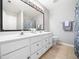 Well-lit bathroom with double vanity, a large mirror, and a decorative shower curtain at 5505 Crabtree Park Ct, Raleigh, NC 27612